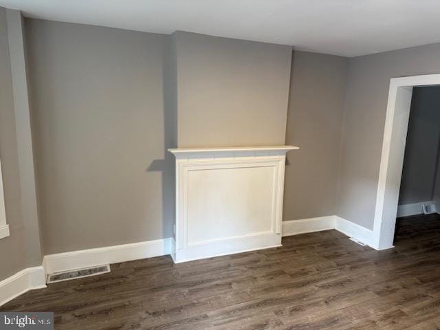 interior space featuring baseboards, dark wood finished floors, and visible vents