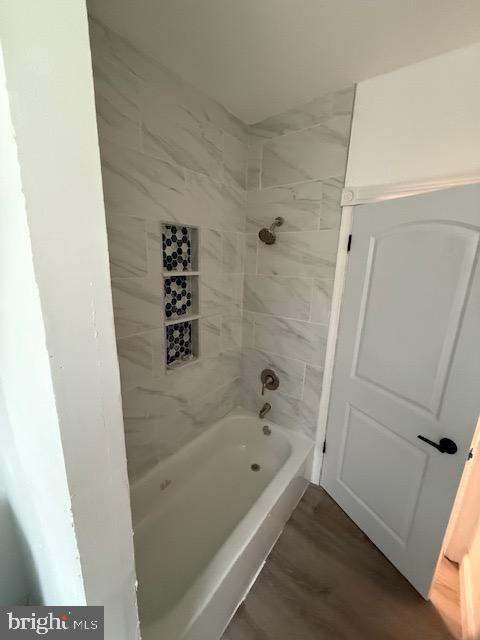 bathroom featuring shower / bathing tub combination and wood finished floors