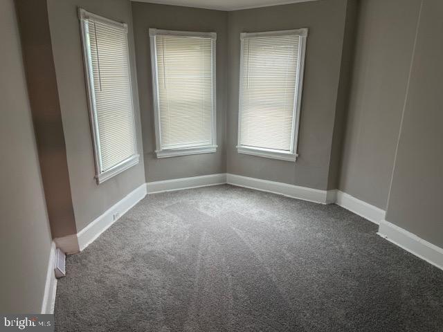 unfurnished room featuring baseboards and carpet flooring