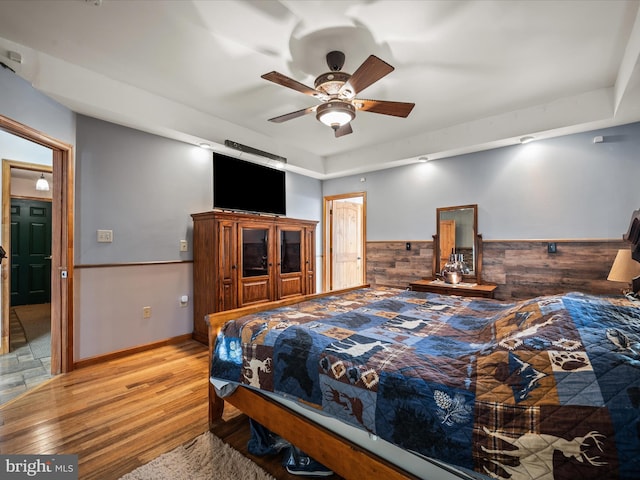 373 Thunder Hill Dr, Summit Point, WV 25446 - bedroom with wood finished floors, a wainscoted wall, and a ceiling fan