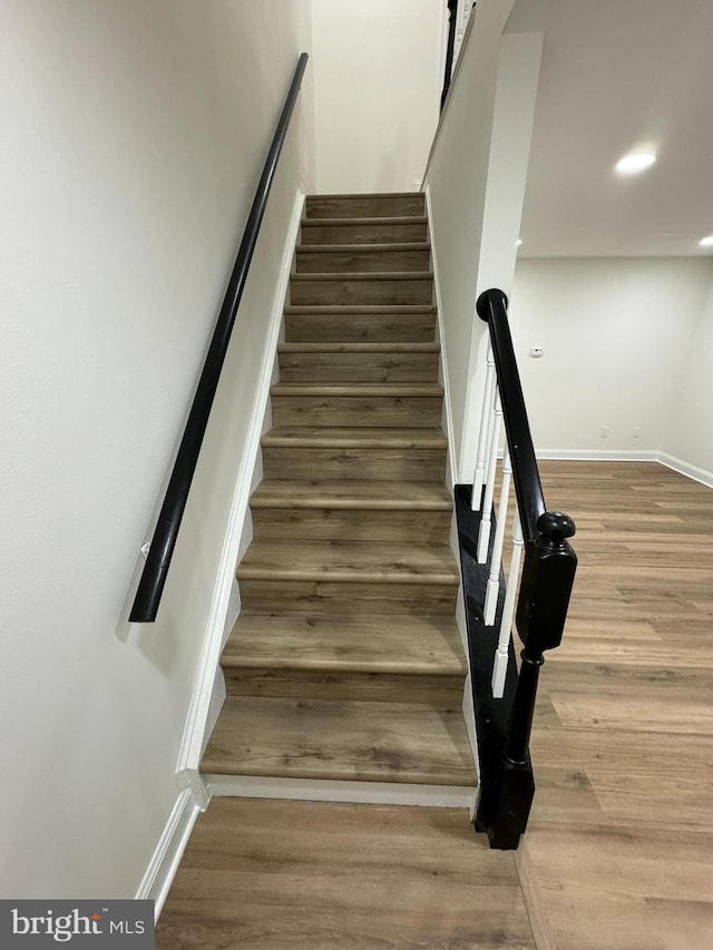 staircase featuring baseboards, recessed lighting, and wood finished floors