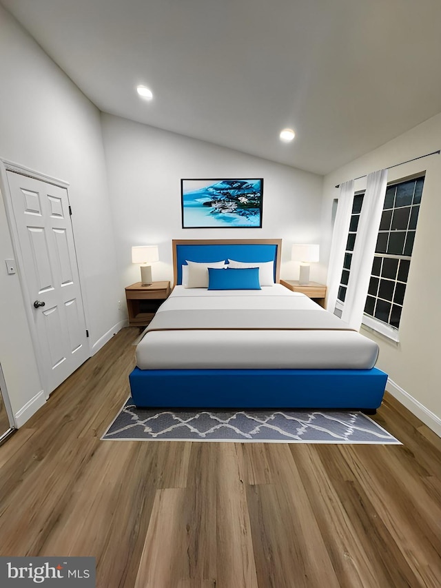 bedroom featuring baseboards, vaulted ceiling, recessed lighting, and wood finished floors