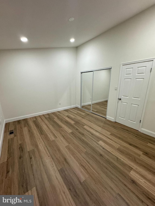 unfurnished bedroom featuring recessed lighting, baseboards, wood finished floors, and visible vents