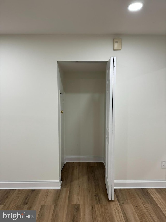hall featuring recessed lighting, baseboards, and wood finished floors