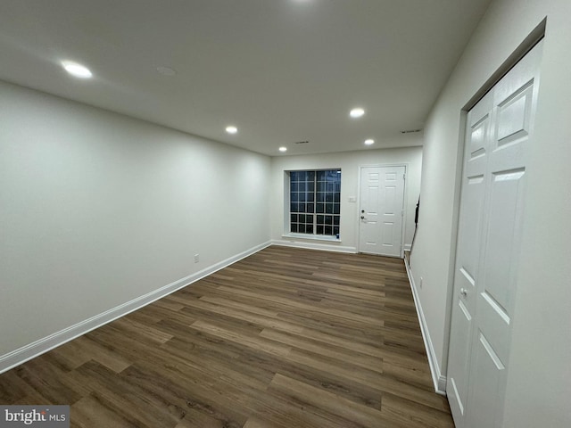 empty room featuring recessed lighting, baseboards, and dark wood-style floors