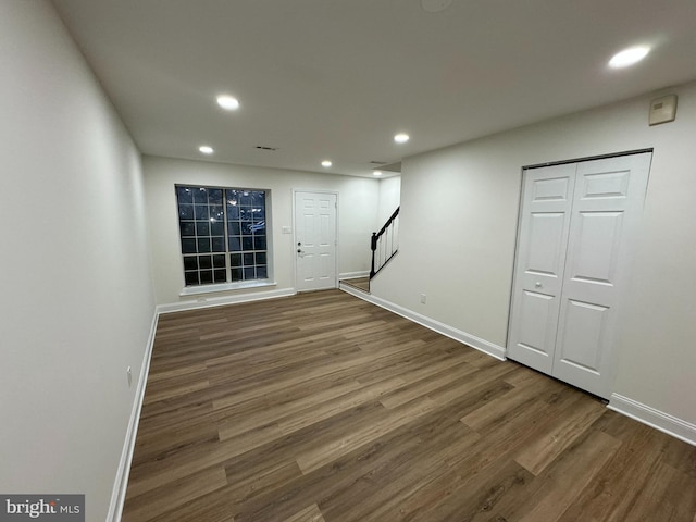 basement featuring recessed lighting, baseboards, stairs, and wood finished floors