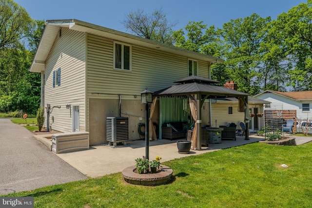 rear view of house with a patio, a gazebo, a yard, and central AC unit