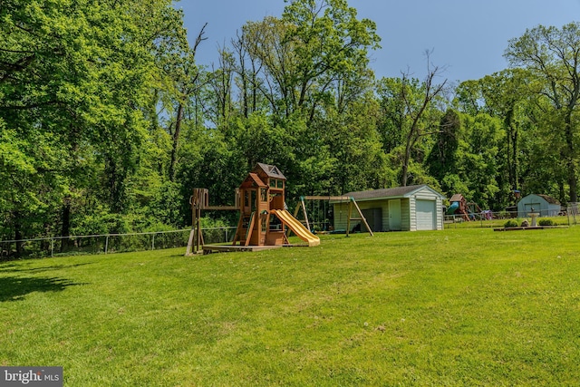 view of play area with fence, an outdoor structure, a lawn, and a shed