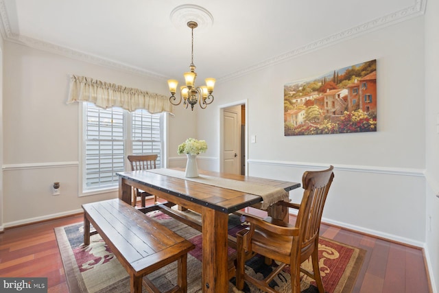 dining room with a chandelier, wood finished floors, baseboards, and crown molding