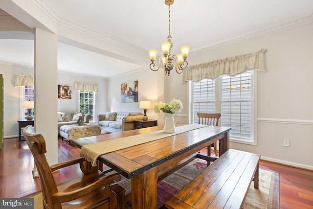 dining area with crown molding, a chandelier, hardwood / wood-style flooring, and baseboards