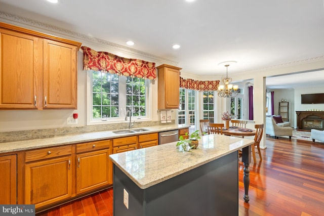 kitchen featuring a sink, dark wood-style flooring, a chandelier, light stone countertops, and healthy amount of natural light