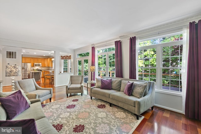 living room featuring plenty of natural light, baseboards, and ornamental molding