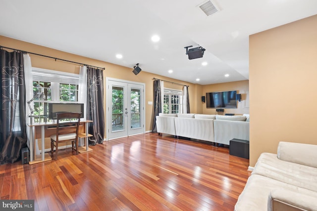 living area with wood finished floors, french doors, and recessed lighting