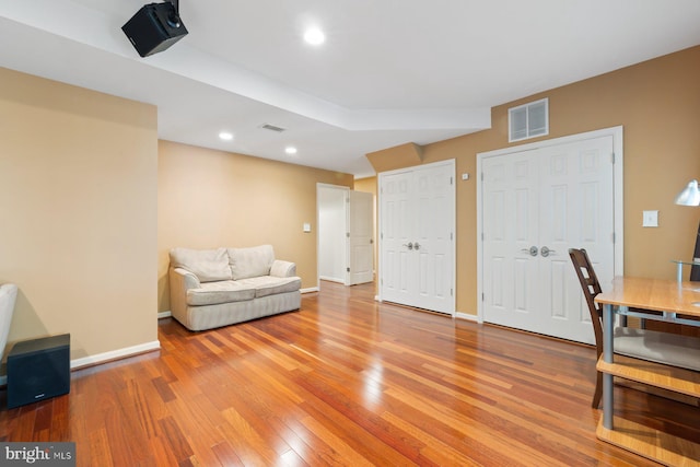 living area featuring light wood-style flooring, baseboards, and recessed lighting