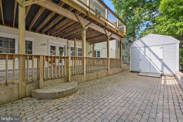 view of patio / terrace with a storage shed, an outbuilding, a wooden deck, and french doors