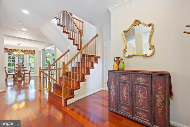 staircase featuring ornamental molding, a chandelier, wood finished floors, baseboards, and recessed lighting