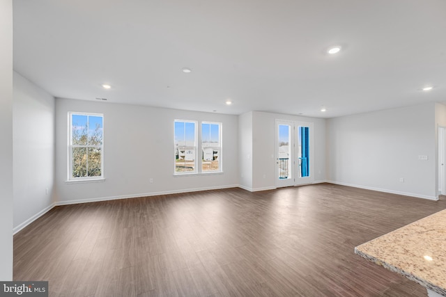 unfurnished living room featuring recessed lighting, dark wood finished floors, and a healthy amount of sunlight