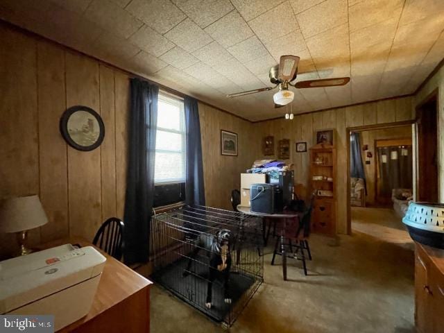 office featuring wooden walls and ceiling fan