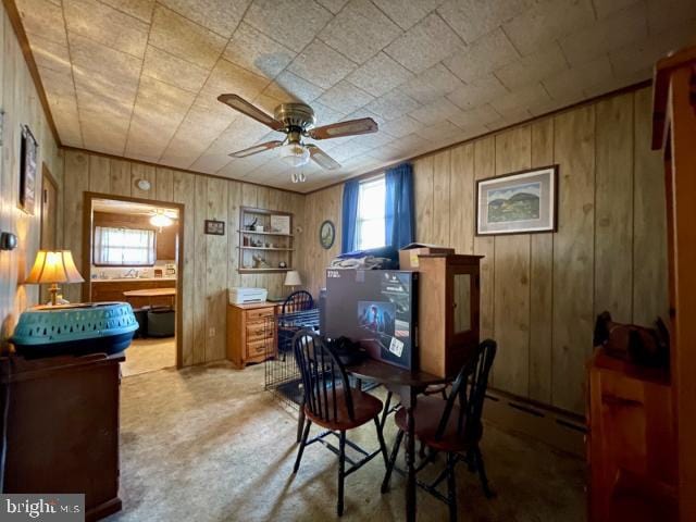 home office featuring a ceiling fan, wood walls, and baseboard heating
