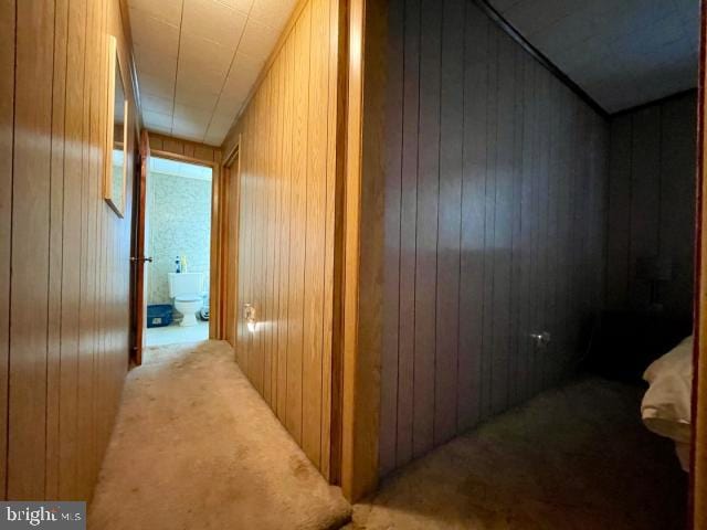 corridor with wooden walls and carpet flooring