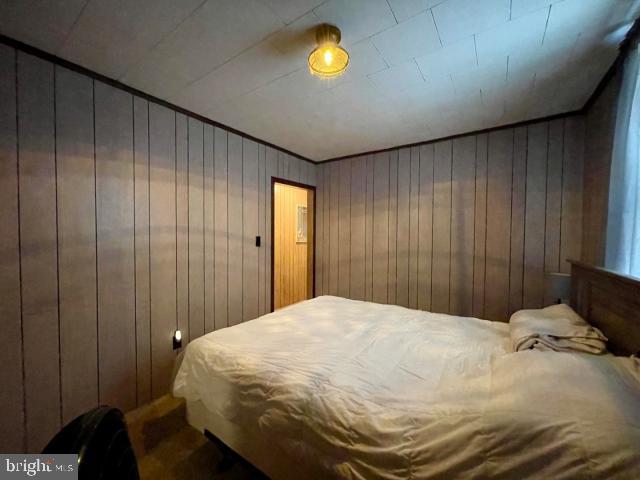 bedroom featuring wood walls