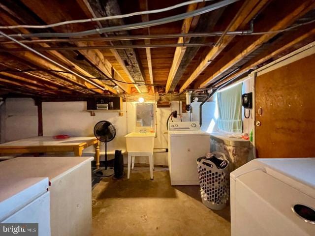 unfinished basement featuring a sink and separate washer and dryer