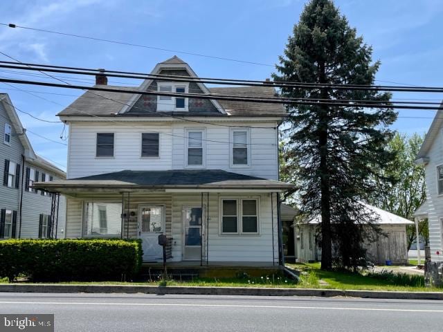 view of front of house featuring covered porch and a chimney