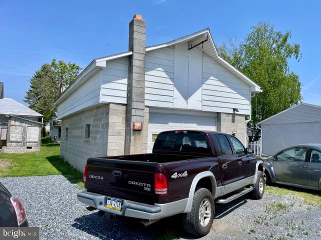 view of side of home with a chimney and a garage