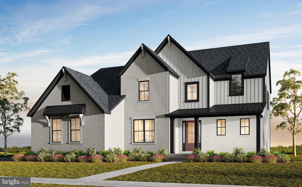 modern inspired farmhouse with brick siding, board and batten siding, a lawn, and a standing seam roof