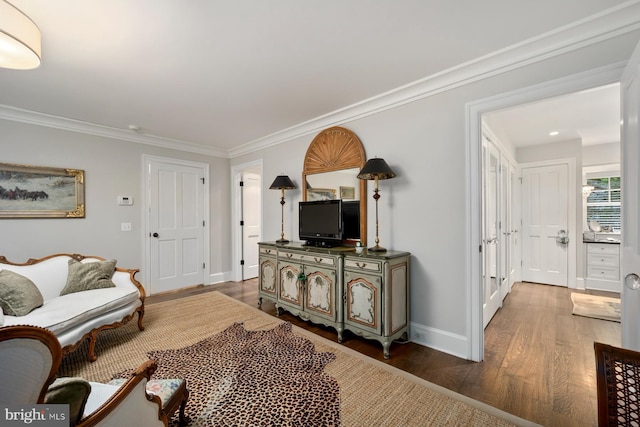living room with wood finished floors, ornamental molding, and baseboards