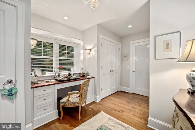 home office featuring built in study area, light wood finished floors, baseboards, and recessed lighting