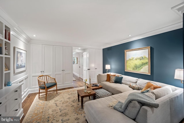 living room featuring wood finished floors, crown molding, and recessed lighting