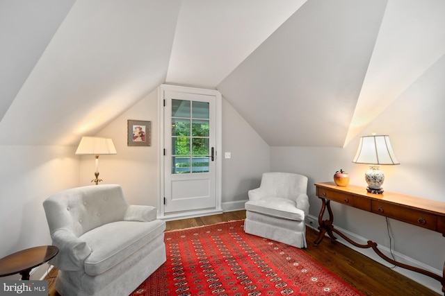 living area with wood finished floors, baseboards, and vaulted ceiling