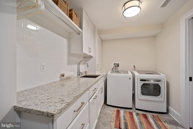 laundry area with washer and clothes dryer, cabinet space, and baseboards