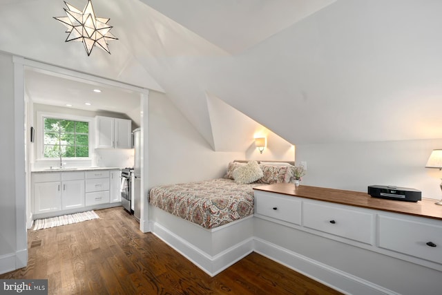 bedroom featuring a sink, vaulted ceiling, wood finished floors, and baseboards