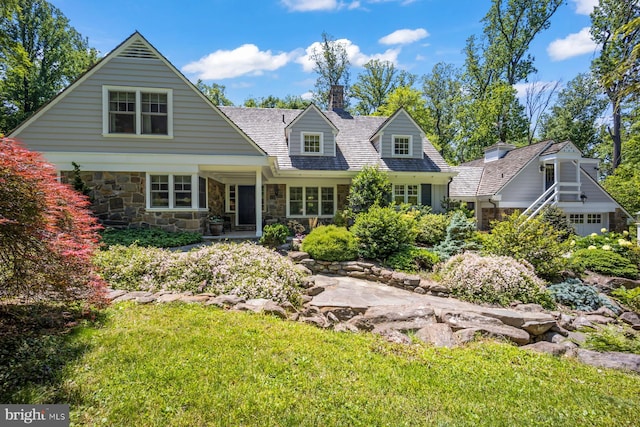 1660 Mount Pleasant Rd, Villanova, PA 19085 - cape cod home featuring a chimney, stone siding, and a front lawn