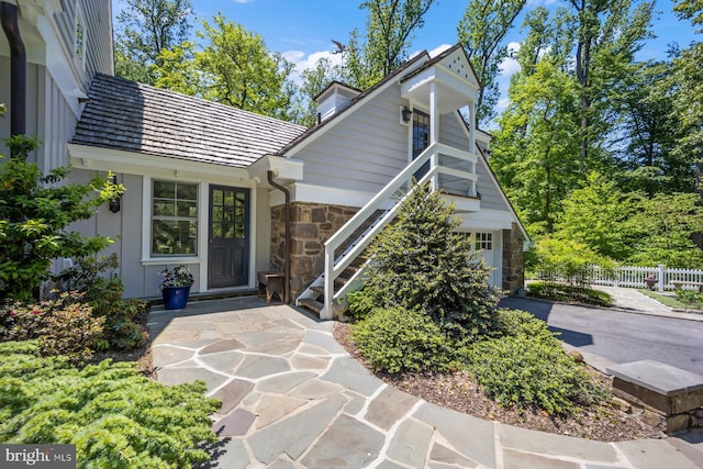 1660 Mount Pleasant Rd, Villanova, PA 19085 - view of exterior entry featuring stone siding, aphalt driveway, a garage, and fence