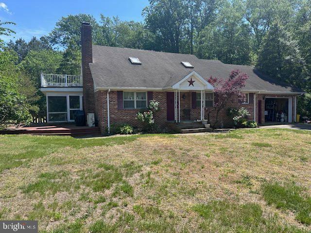 14957 Cherry Ln, Ridgely, MD 21660 - view of front of property featuring an attached garage, a front lawn, brick siding, and covered porch