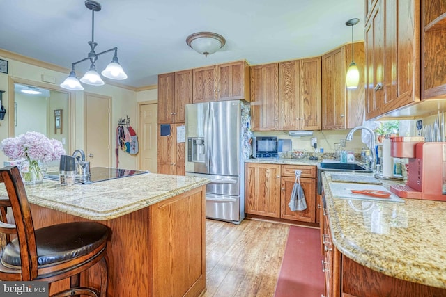 14957 Cherry Ln, Ridgely, MD 21660 - kitchen featuring stainless steel fridge with ice dispenser, a breakfast bar area, brown cabinetry, light wood-type flooring, and crown molding