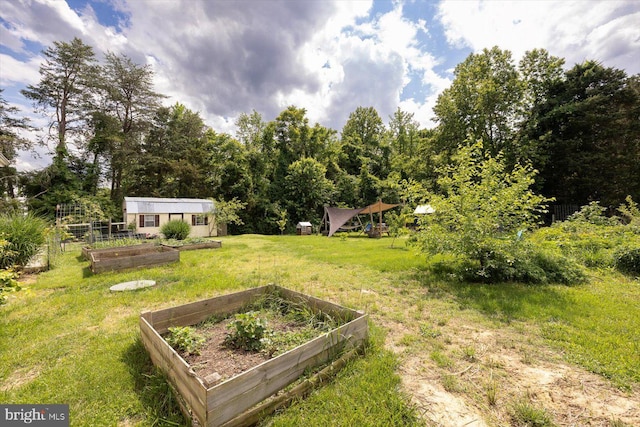 view of green lawn with a garden and an outbuilding