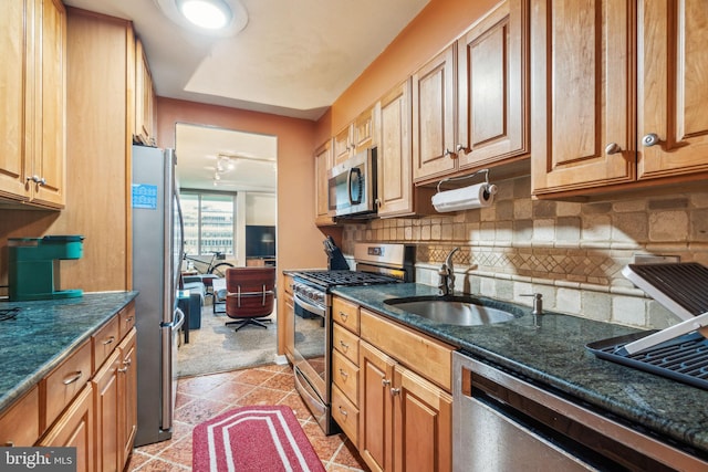 604 S Washington Sq Unit 1408, Philadelphia, PA 19106 - kitchen featuring appliances with stainless steel finishes, a sink, backsplash, dark stone countertops, and brown cabinetry