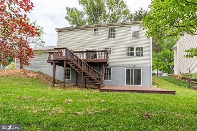 rear view of property featuring a lawn, a wooden deck, and stairs
