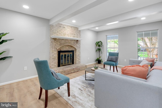 living area with baseboards, wood finished floors, and beam ceiling