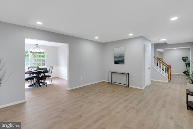 interior space featuring stairs, recessed lighting, an inviting chandelier, and light wood finished floors