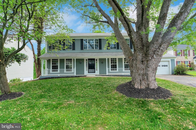 colonial inspired home featuring a front lawn, aphalt driveway, and covered porch