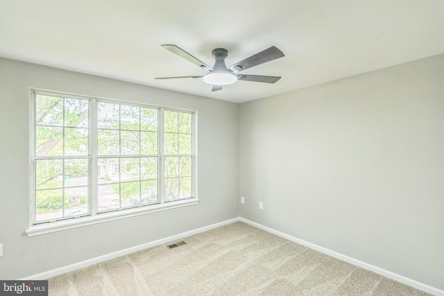 carpeted empty room featuring baseboards, ceiling fan, and visible vents