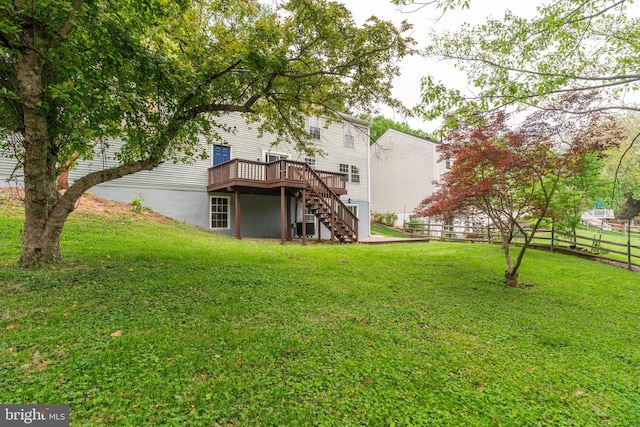 rear view of house featuring stairway, a deck, a yard, and fence