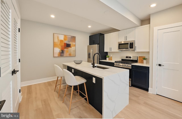 kitchen with recessed lighting, a sink, light wood-type flooring, and stainless steel appliances