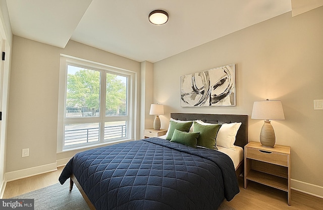 bedroom with baseboards and wood finished floors
