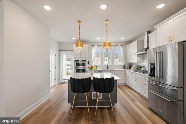 17303 Turnstone Dr, Dumfries, VA 22026 - kitchen with stainless steel appliances, wall chimney range hood, backsplash, a sink, and a center island